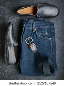 Flat Lay Mens Jeans, Moccasins And Leather Belt, Mens Fashion, Top View, Dark Gray Background