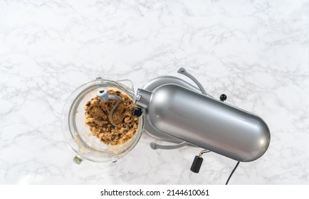 Flat lay. Mixing ingredients in a kitchen stand mixer to bake soft oatmeal raisin walnut cookies.
