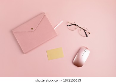 Flat lay with mock up of golden credit card, glasses, notebook and comuter mouse over the pink background. Online shopping concept