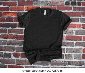 Flat lay mockup of charcoal gray tshirt on brick background for product mockup: zdjęcie stockowe