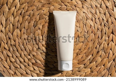 Flat lay mockup of white plastic tube with moisturizer cream, facial cleanser on natural background with deep shadows. Concept bio organic beauty products