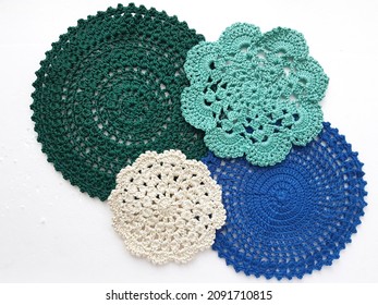 Flat lay multicolored crochet doilies pattern on white background