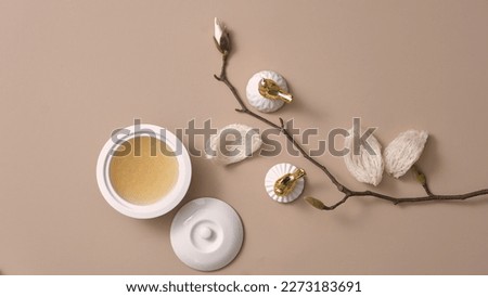 Flat lay of bird’s nest soup contained in a porcelain bowl, decorated with edible bird’s nest and a flower branch. Bird’s nest is a expensive and high-class dessert