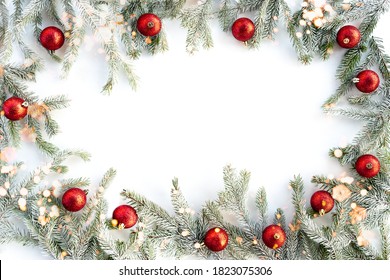 Flat lay new year christmas red balls and pine tree with snow flakes and lights . High quality photo