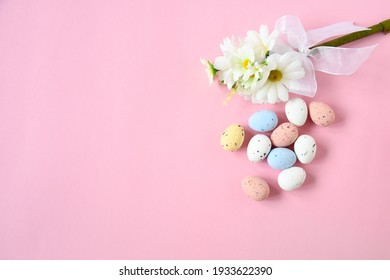 Flat lay non focus easter background with bouquet white flwoer and easter eggs in soft color on pink background decorate and text copy space, happy and funny season in april