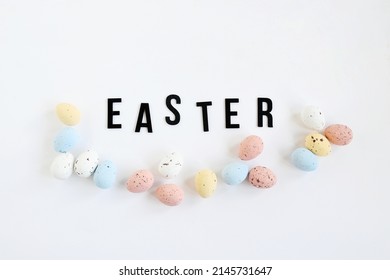 Flat lay non focus easter background with bouquet white flwoer and easter eggs in soft color on white background decorate and wooden black text , happy and funny season in april