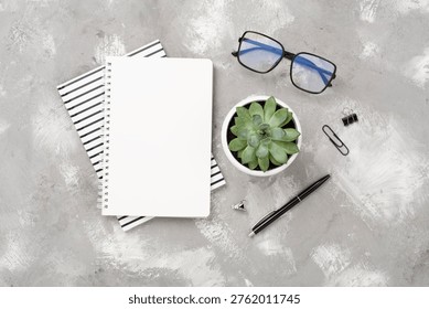 Flat lay with notebook and cup of coffee on concrete background. Office workplace