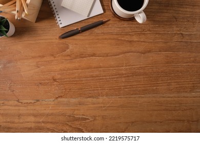 Flat Lay Notepad, Cup Of Coffee, Pen And Pencil Holder On Wooden Table. Top View With Copy Space.