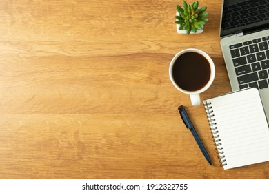 Flat Lay Of Office Desk With Laptop, And Blank Notepad With A Coffee Cup On Wood Table, Copy Space, Top View