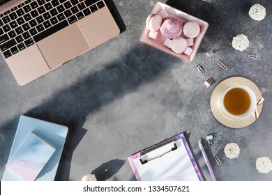 Flat Lay Of Office Stationery With Cup Of Tea With Marshmallow And Laptop On A Gray Background With Shadows. Table Desk With Office Tools, Flatlay And Top View