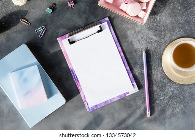 Flat Lay Of Office Stationery With Cup Of Tea With Marshmallow And Laptop On A Gray Background With Shadows. Table Desk With Office Tools, Flatlay And Top View