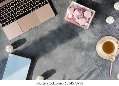 Flat Lay Of Office Stationery With Cup Of Tea With Marshmallow And Laptop On A Gray Background With Shadows. Table Desk With Office Tools, Flatlay And Top View