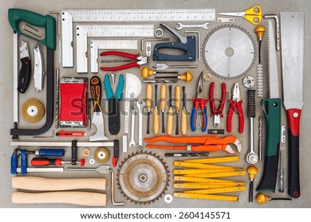 Flat lay of old hand tools on concrete background. Large collection of various rusty tools and bits arranged on concrete.