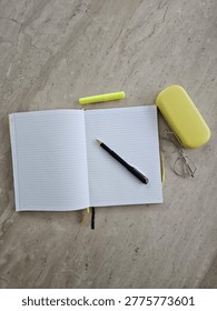 Flat Lay Of Open Lined Notebook With Pen On Stone Surface With Glasses