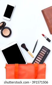 Flat Lay Of Orange Woman Bag Open Out With Tablet, Smartphone, Purse And Cosmetics On White Background