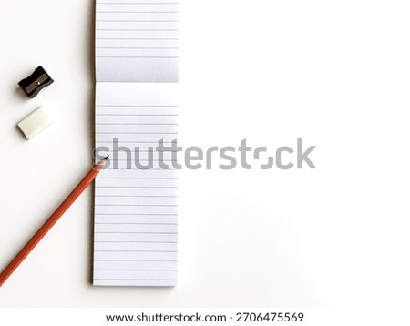 Flat Lay Overhead View Of Lined Notepad With Pencil And Basic Stationery On White Background