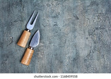 Flat lay of parmesan cheese knives with wooden handles and copy space on gray concrete background - Powered by Shutterstock