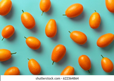 Flat lay pattern of fresh kumquats on a colorful background. Top view