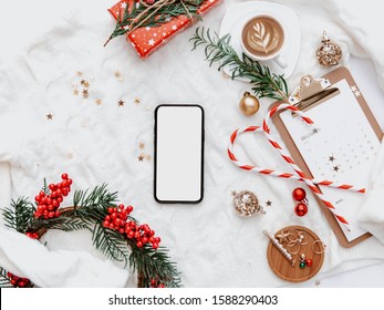 Flat lay phone mock up. Cozy winter holiday. Christmas background with decorations on a light background - Powered by Shutterstock