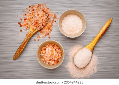 A flat lay photo of coarse and fine Himalayan pink salt in bowls and on spoons. - Powered by Shutterstock