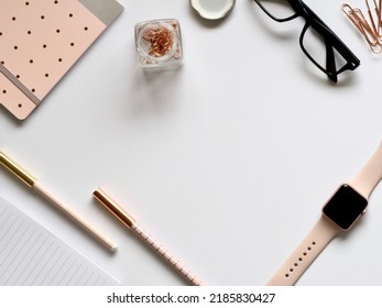 Flat Lay Photo Of The Gold Apple Watch, Clear Eyeglasses, And Pens