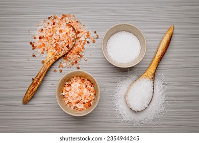 A flat lay photo os coarse Himalayan pink salt and coarse white sea salt in bowls and on wooden spoons. - Powered by Shutterstock