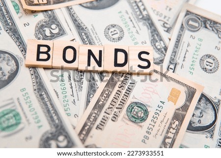 flat lay photo showing us dollars and the word bonds. Bonds are a type of debt securities