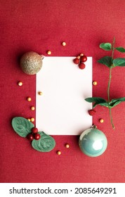 A Flat lay photo with whitespace and christmas decorations where someone can add their own message on the card. A bright red background, no people. Can be used as a Greeting Card. Vertical image