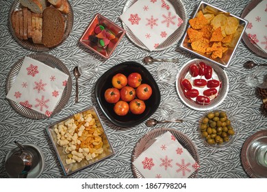 Flat lay photography of still food (tomatoes, cherry tomatoes, bread, snacks...) plated on a table with a tablecloth waiting to be eaten - Powered by Shutterstock