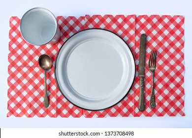 Flat Lay Picnic Table Place Setting Of Plate, Cup, Silverware, And Checkered Tablecloth