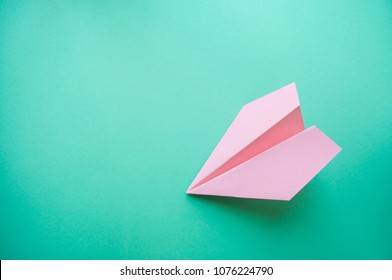 Flat Lay Of Pink Paper Plane On Pastel Turqoise Color Background With Text Space.