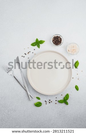 A flat lay of a place setting with spices and basil.