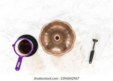 Flat lay. Preparing the bundt cake pan for baking, a mixture of melted vegetable shortening and cocoa powder is skillfully applied to ensure easy release and a beautifully baked bundt cake. - Shutterstock ID 2396042967