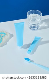 Flat lay of razor, toothpaste, and glass on white surface. Modern and clean—great for grooming or personal care visuals.