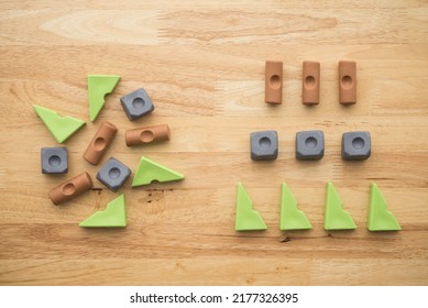 Flat lay of rearrange vary shape and color geometry block from left to right on wooden table background. Renovation, arrange category in business, company and education concept.
