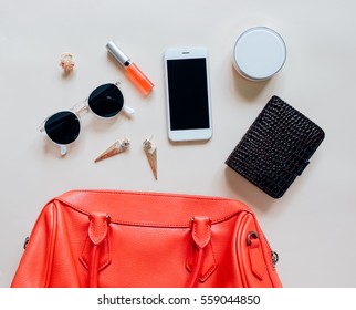 Flat Lay Of Red Leather Woman Bag Open Out With Cosmetics, Accessories And Smartphone On Yellow Background