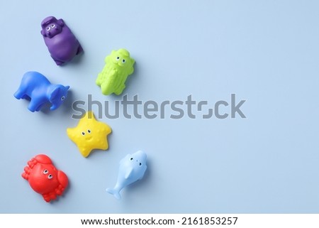 Flat lay rubber baby toys for bath on blue background with copy space. Top view.