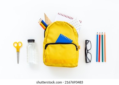 Flat lay of school backpack with school items and student accessories, top view