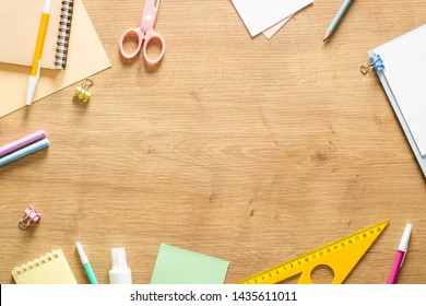 Flat Lay School Stationery On A Wooden Background. Back To School Concept, Creative Layout. Top View, Overhead. 