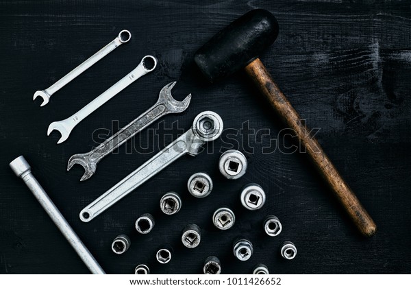 Flat lay of set of tools for\
car repairing such as wrenches on black wooden background. Top\
view.