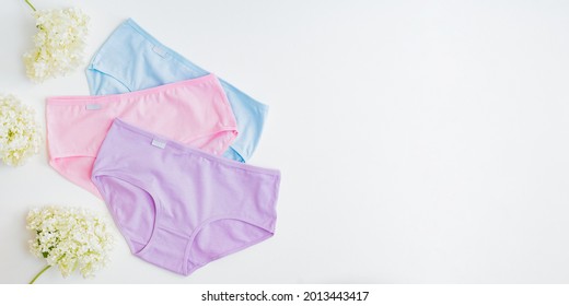 Flat lay set of women panties of different colors on a white background. Top view advertising and shopping concept