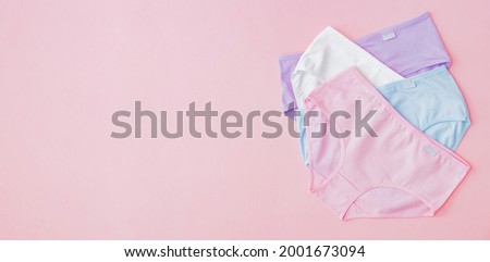 Flat lay set of women panties of different colors on a pink background. Top view advertising and shopping concept