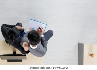 Flat lay shot of Asian business people sitting,  woman holding notebook computer in her hand , man checking report from screen and takes short note in office. - Shutterstock ID 1449612242