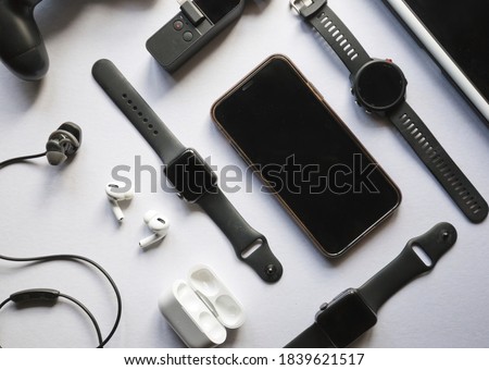Flat lay shot of gadgets and mobile devices in white background. 