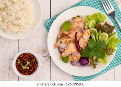 Flat lay sliced grilled chicken breast salad or nam tok gai n in Thai, a hot, sour, clean, healthy and lean dish in Isan Thai food style, served with sticky rice, Jaew dipping sauce and vegetables.