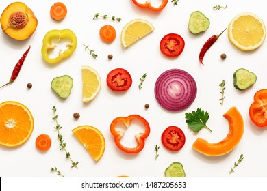 Flat lay slices of vegetables and fruits on a white background, isolated. View from above.