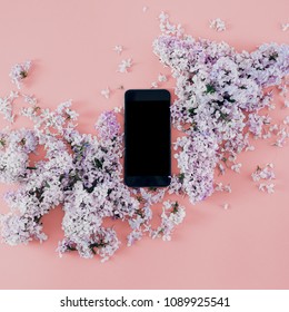 Flat lay smart phone with a bouquet of lilacs on pink background, top view - Shutterstock ID 1089925541