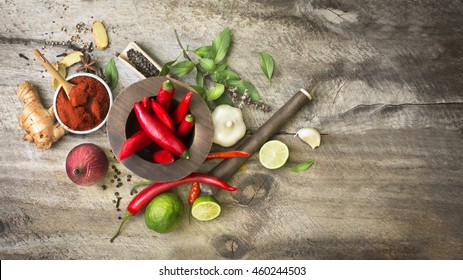 Flat Lay South East Asian Cuisine Recipe Herbs, Spices And Other Ingredients With Wooden Traditional Food Grinder On Rustic Wooden Background. Horizontal View Text Space Images.