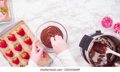 Flat lay. Step by step. Dipping organic strawberries into melted chocolate.