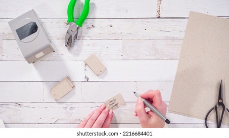 Flat Lay. Step By Step. Labeling Brown Paper Gift Tags With A Black Marker.